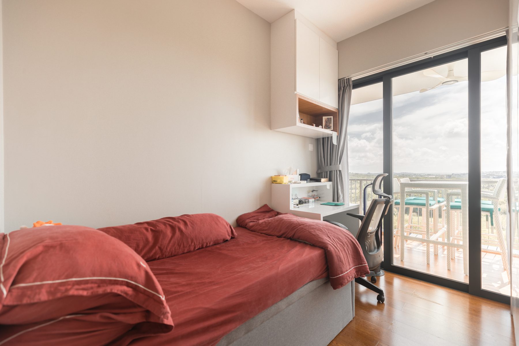 Bedroom 2 with single bed and floor-to-ceiling sliding door opening to a balcony